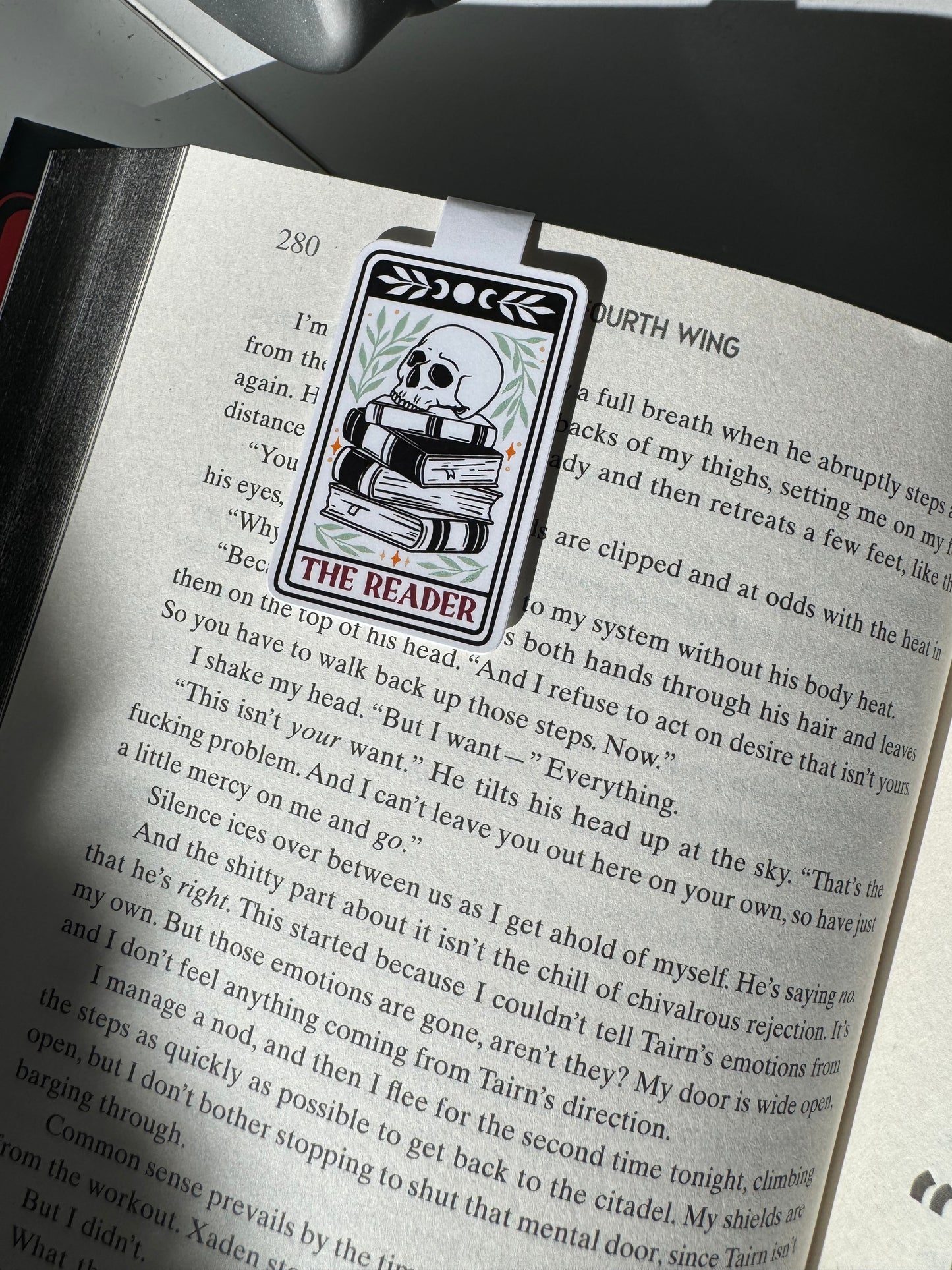 The Reader quote magnetic bookmark with a skull sitting on top of a stack of books